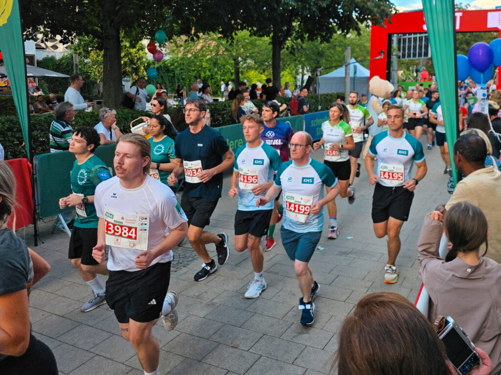 Läufer des KMS-Laufteams in Trikots mit Startnummern beim Firmenlauf Chemnitz auf der Laufstrecke