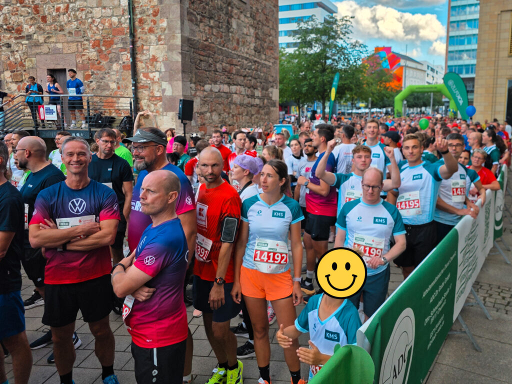 Läufer des KMS-Teams warten motiviert im Startbereich des Firmenlaufs Chemnitz vor historischer Kulisse